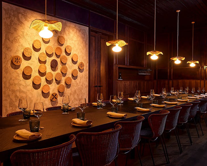 A long table in front of a striking Pasifika-inspired wall art.