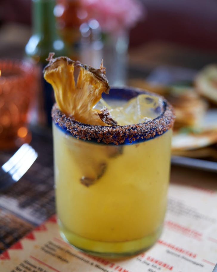 A golden-coloured marg topped with pineapple at Mexicano's. 