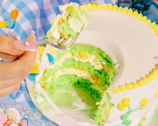A person taking forks out of a large a cake.