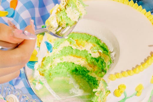 A person taking forks out of a large a cake.