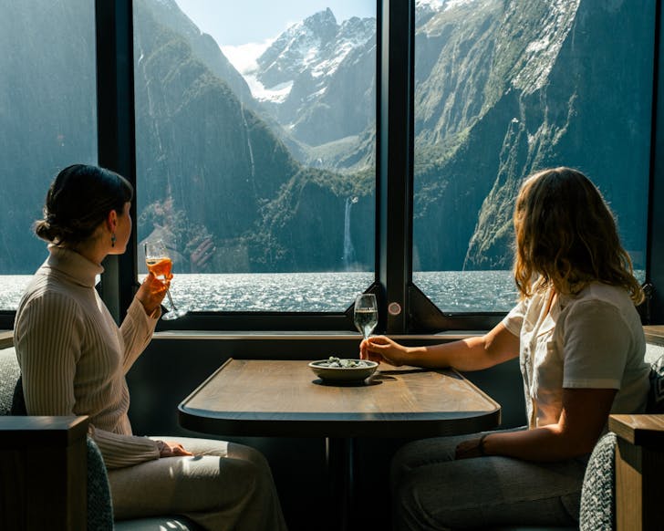 Women drinking wine and enjoying the view of Milford Sound
