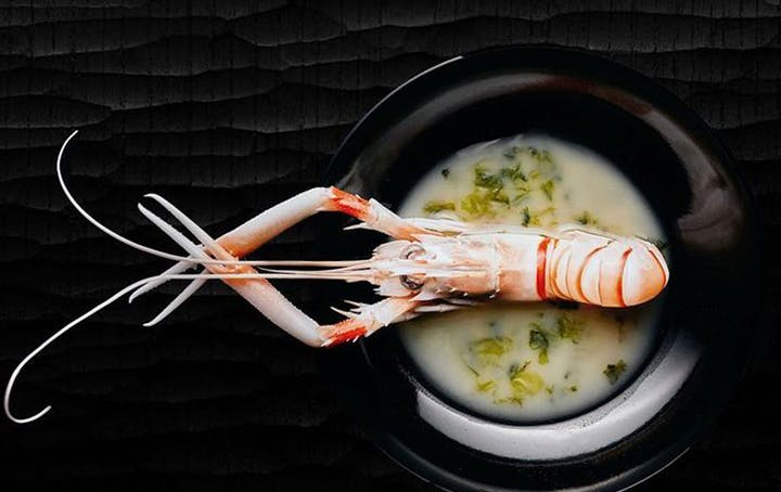 A black table with a single seafood dish at a best japanese restaurant melbourne.