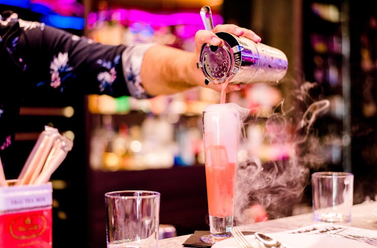 A bartender pours a smoking cocktail on the Gold Coast.