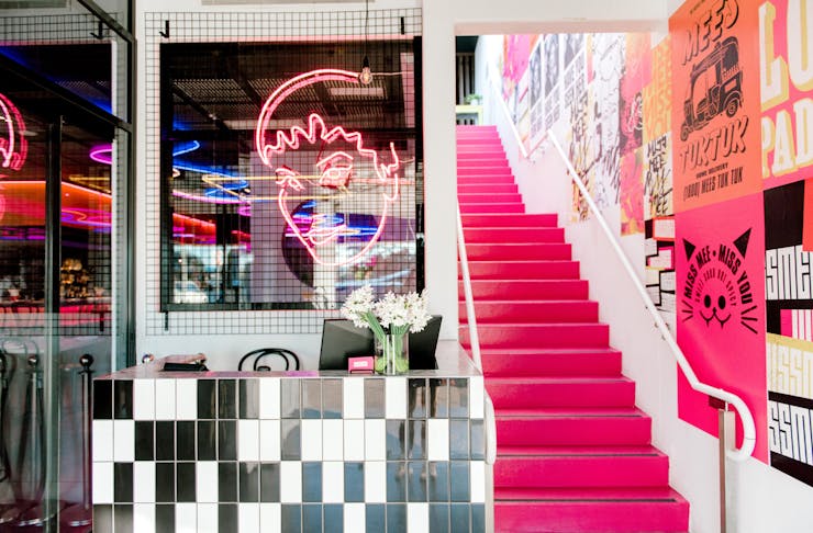 A hot pink staircase connects the two levels at Miss Mee on the Gold Coast.