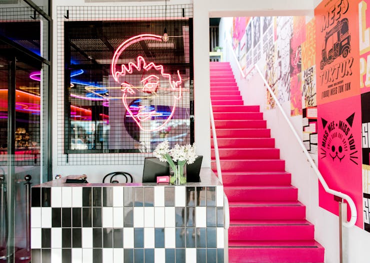 A hot pink staircase connects the two levels at Miss Mee on the Gold Coast.