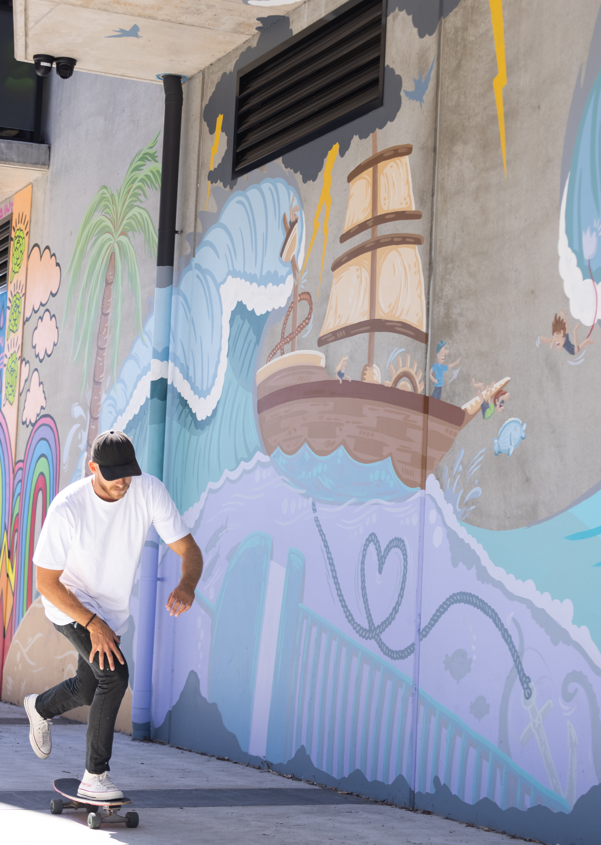 Mitch skates past a mural.