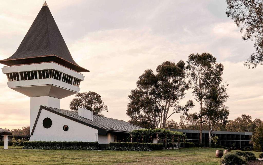A large winery accommodation Victoria, with a large tower and trees around it. 