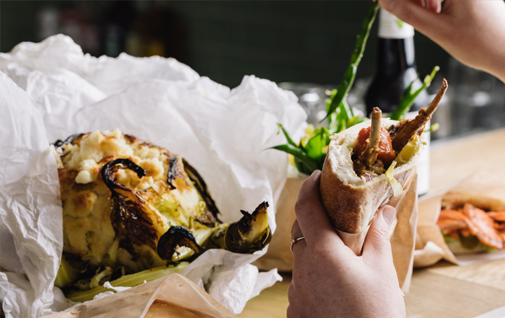 A person holding a pita and eating it, a best cheap eats Melbourne option.