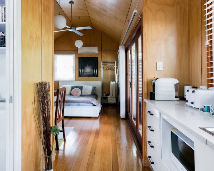 A view of the kitchen and bed area at Modern Studio & Spa pet-friendly Airbnb in Brisbane