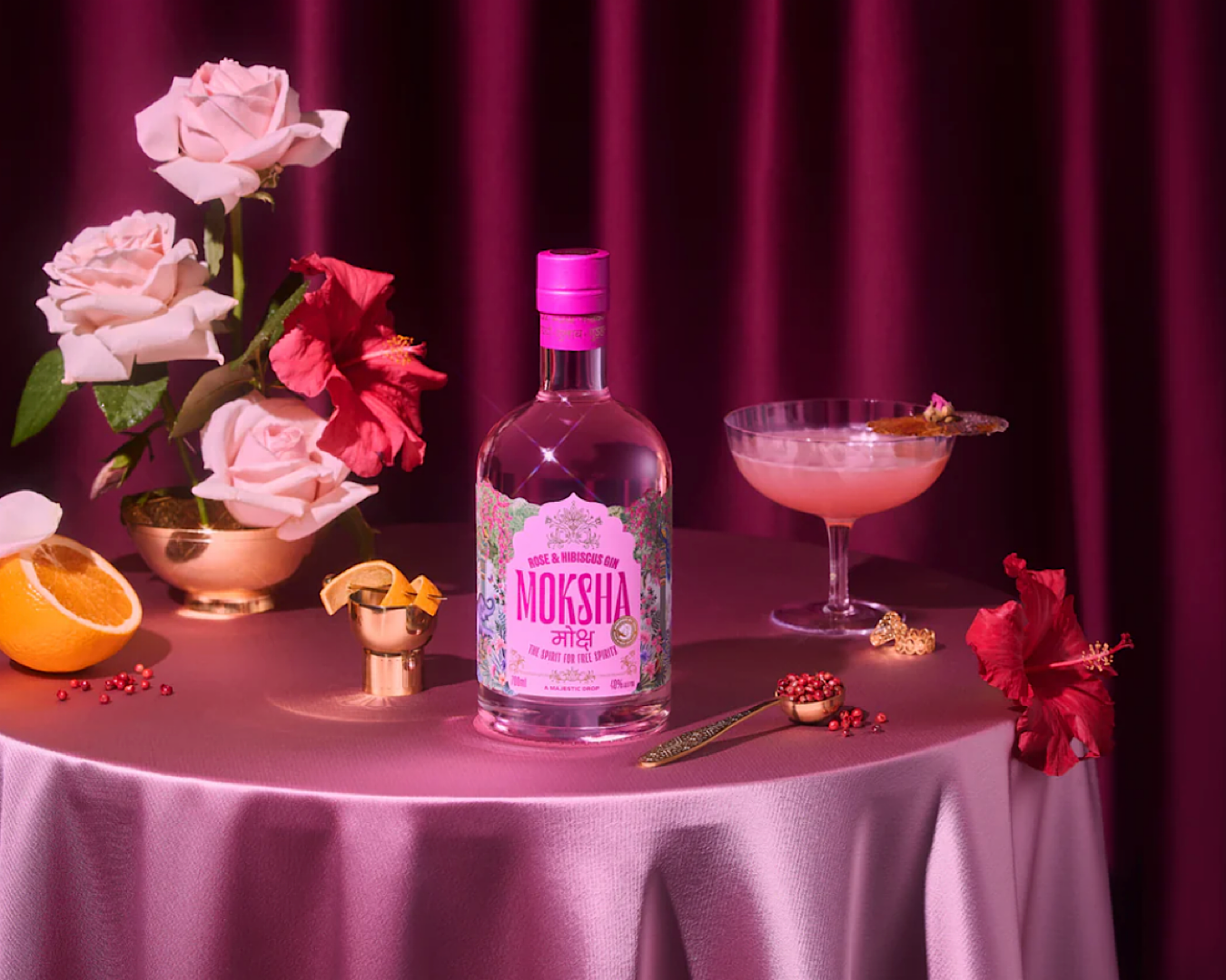 A pink bottle of gin stands temptingly amidst a seductive pink set up. 