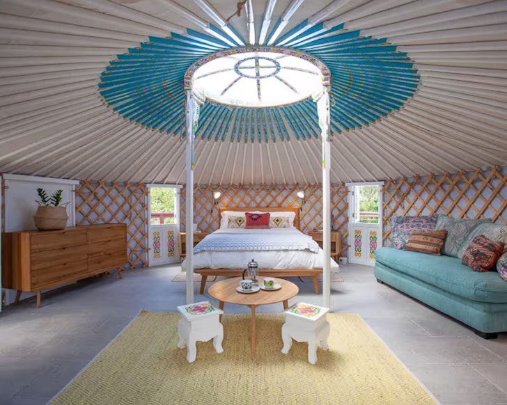 A view of the inside of the Mongolian Style Yurt with its blue roof, one of the best glamping spots in Queensland