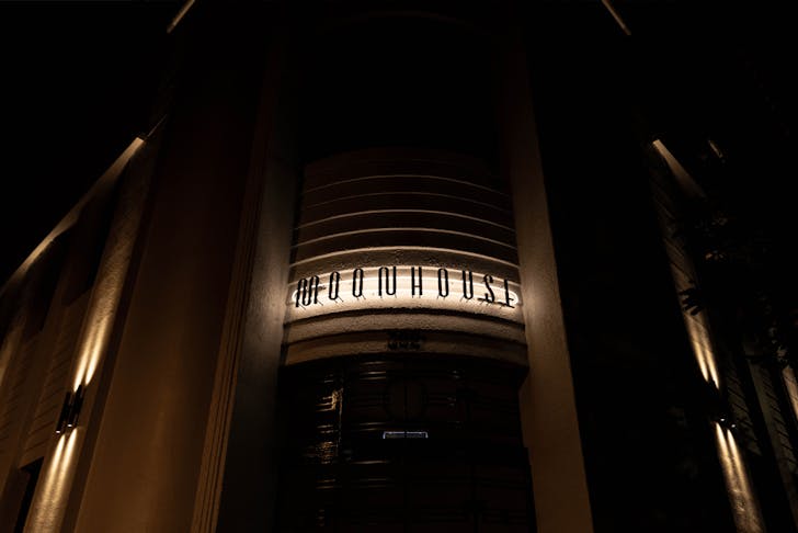 A large building entrance with 'Moonhouse' sign illuminated.