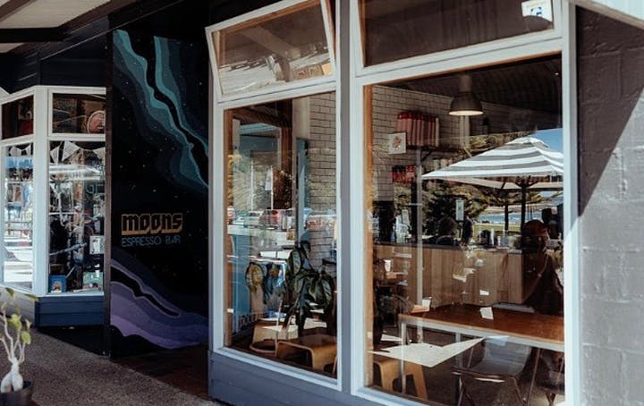 A shopfront window with artwork on the doorway, a best lorne cafe. 
