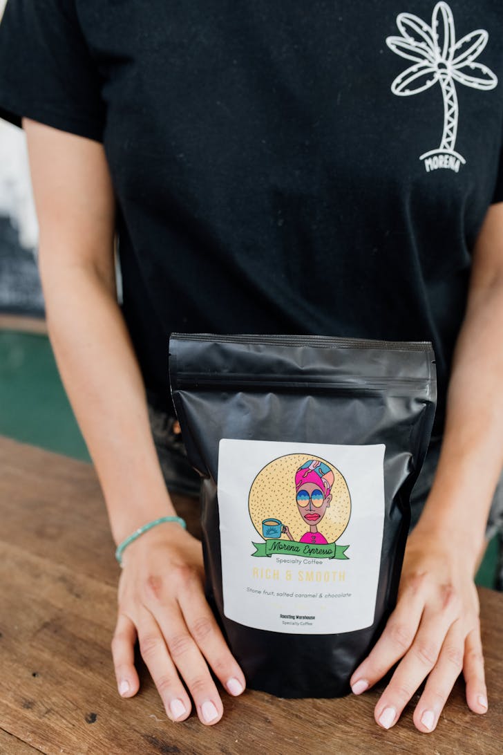 a man holding a bag of ground coffee