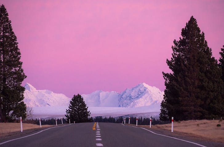 The Mackenzie basin showing snow capped mountains and tall trees.