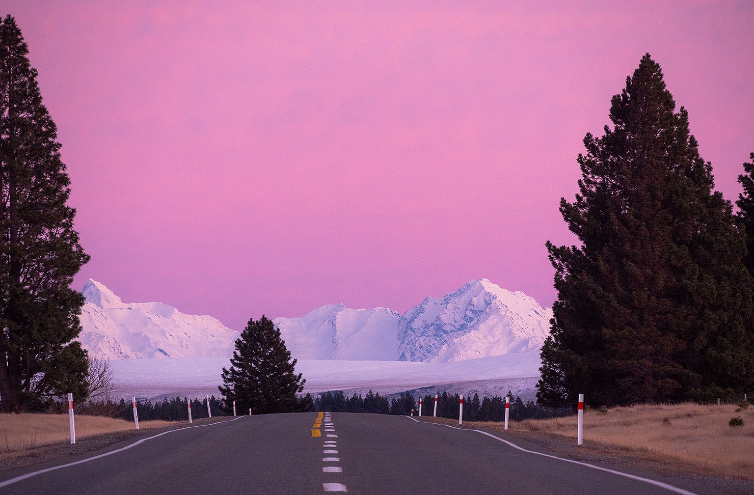 The Mackenzie basin showing snow capped mountains and tall trees.