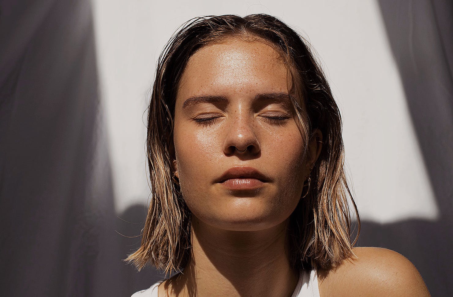 Someone stands with their face in the sun.