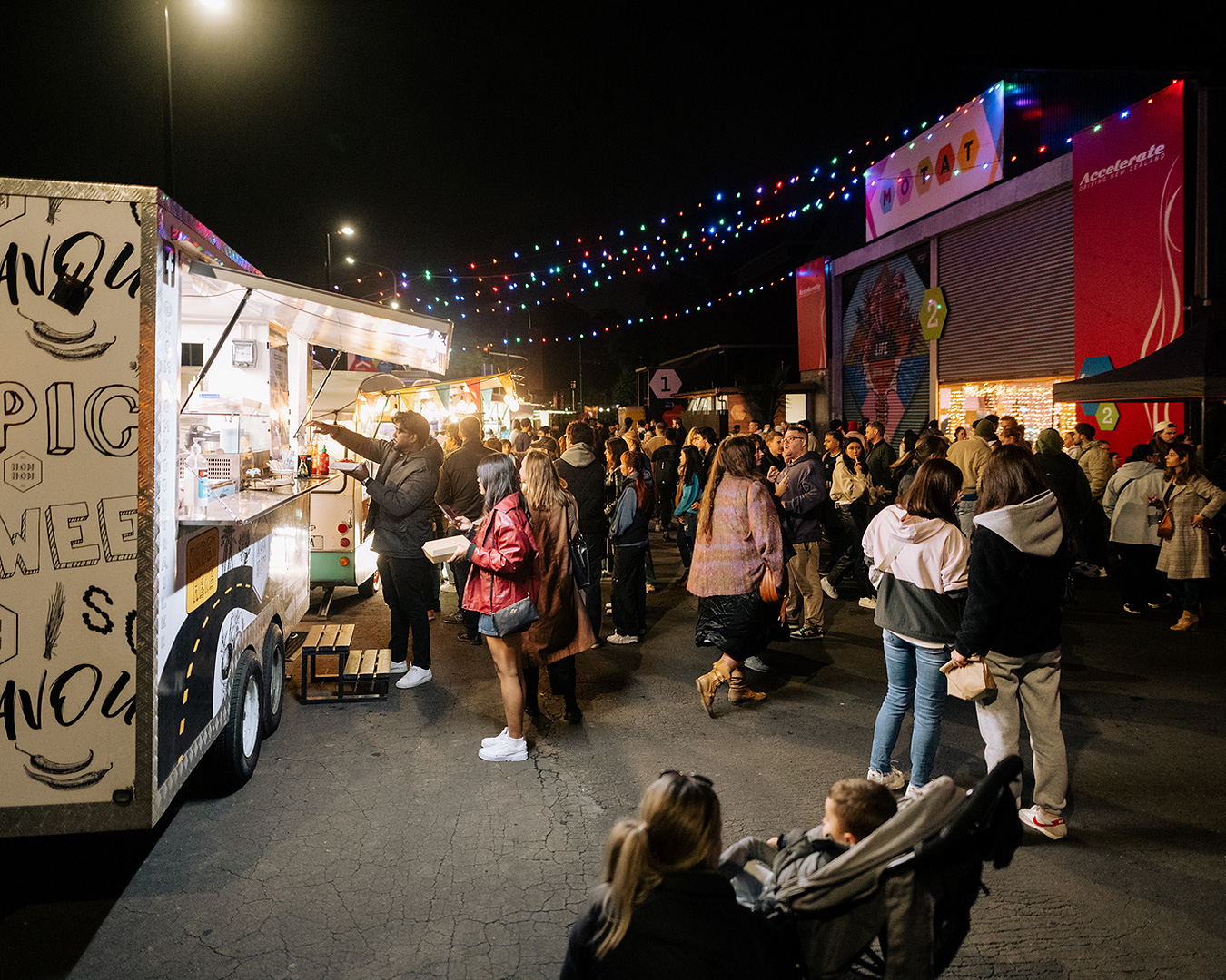 People mill around food trucks at the food truck round up at MOTAT.