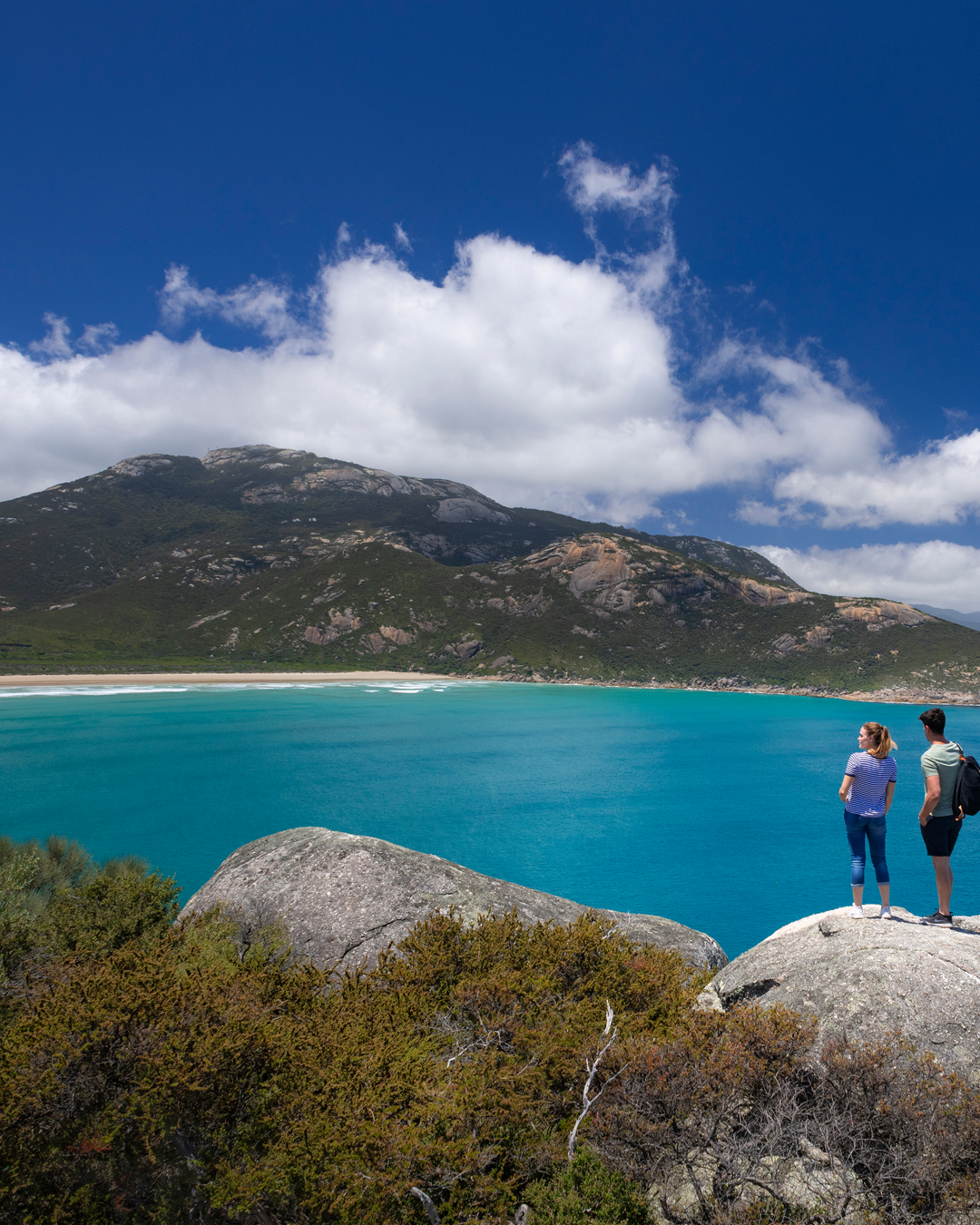 Two people standing looking out of a large bay at one of the best walks in Victoria. 