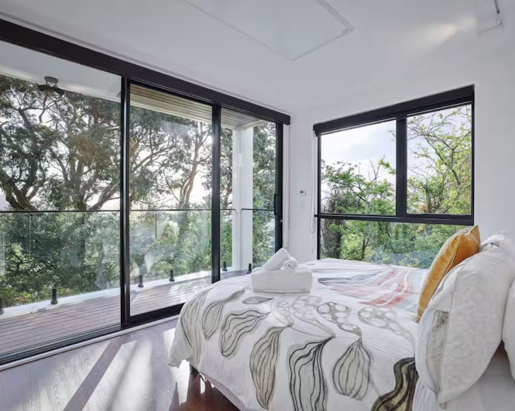 The bedroom with treetop views at Mount Pleasant Hillside Haven romantic stay near Christchurch, New Zealand
