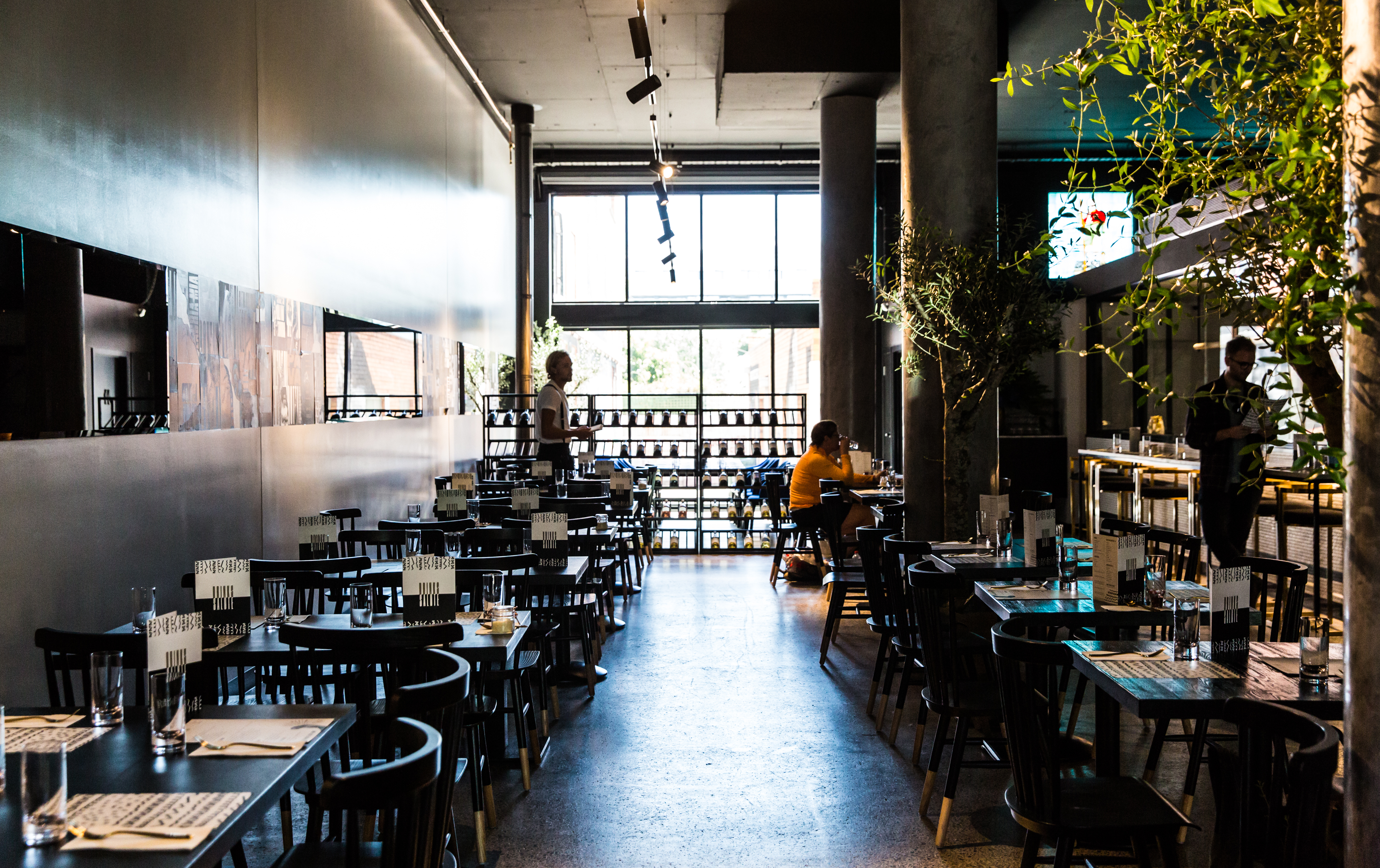 People dining inside a sleek concrete floor at one of the best restaurants Richmond has to offer.