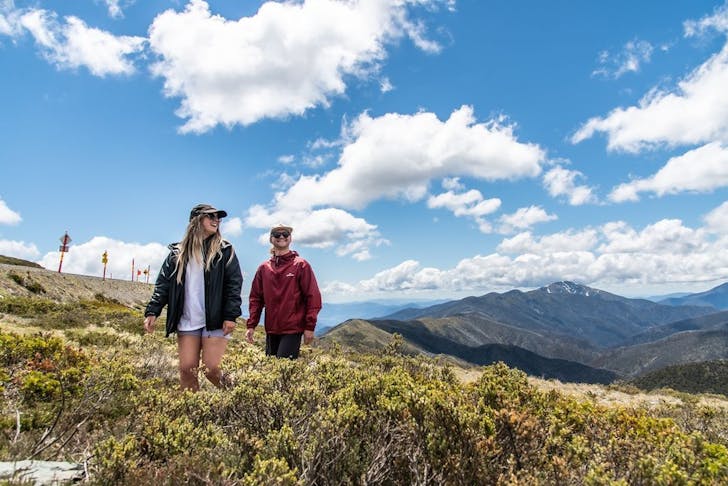 Two people hiking through stunning mountain scenery at Mt Hotham