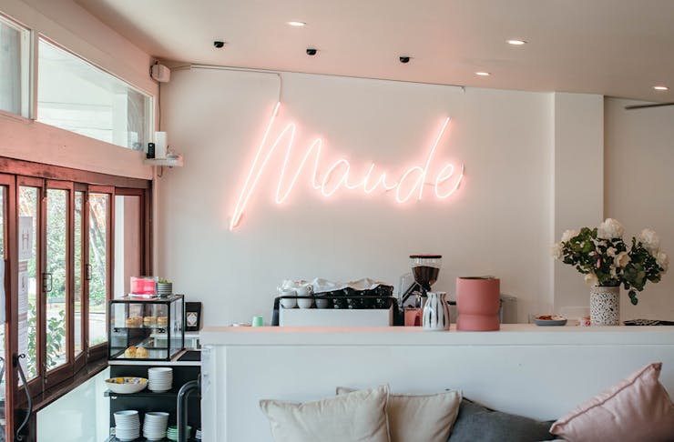 coffee counter at maude with a neon name sign