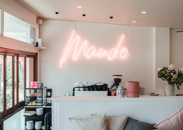 coffee counter at maude with a neon name sign