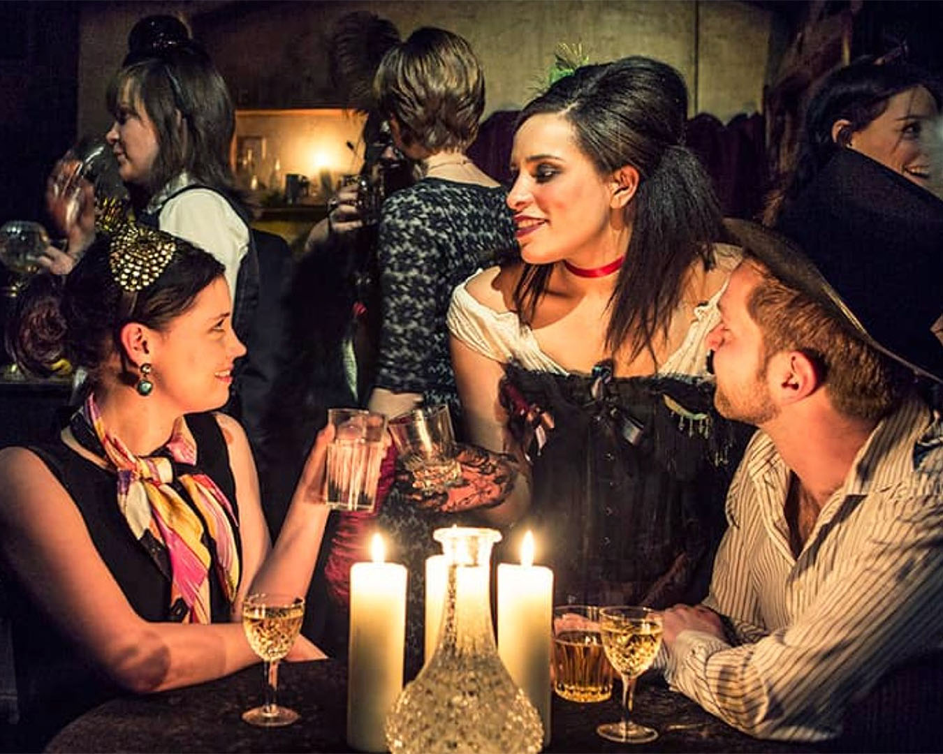 People in period dress enjoy drinks at the Murder Mystery Dinner Theatre.