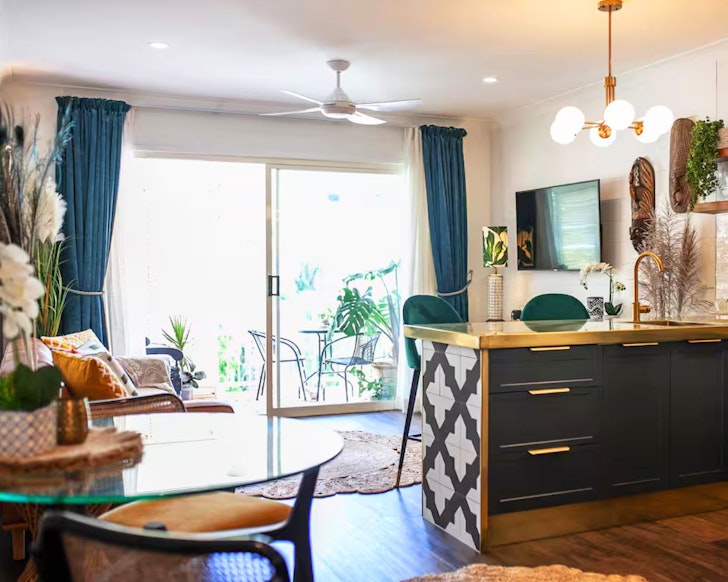 A view of the kitchen and living space leading out to the balcony at Muse one of the best Port Douglas Airbnbs