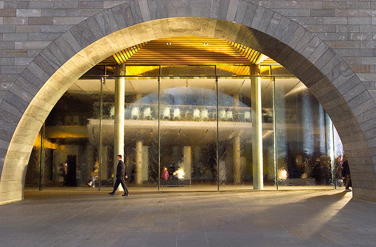 The archway of the NGV with a man walking past. 