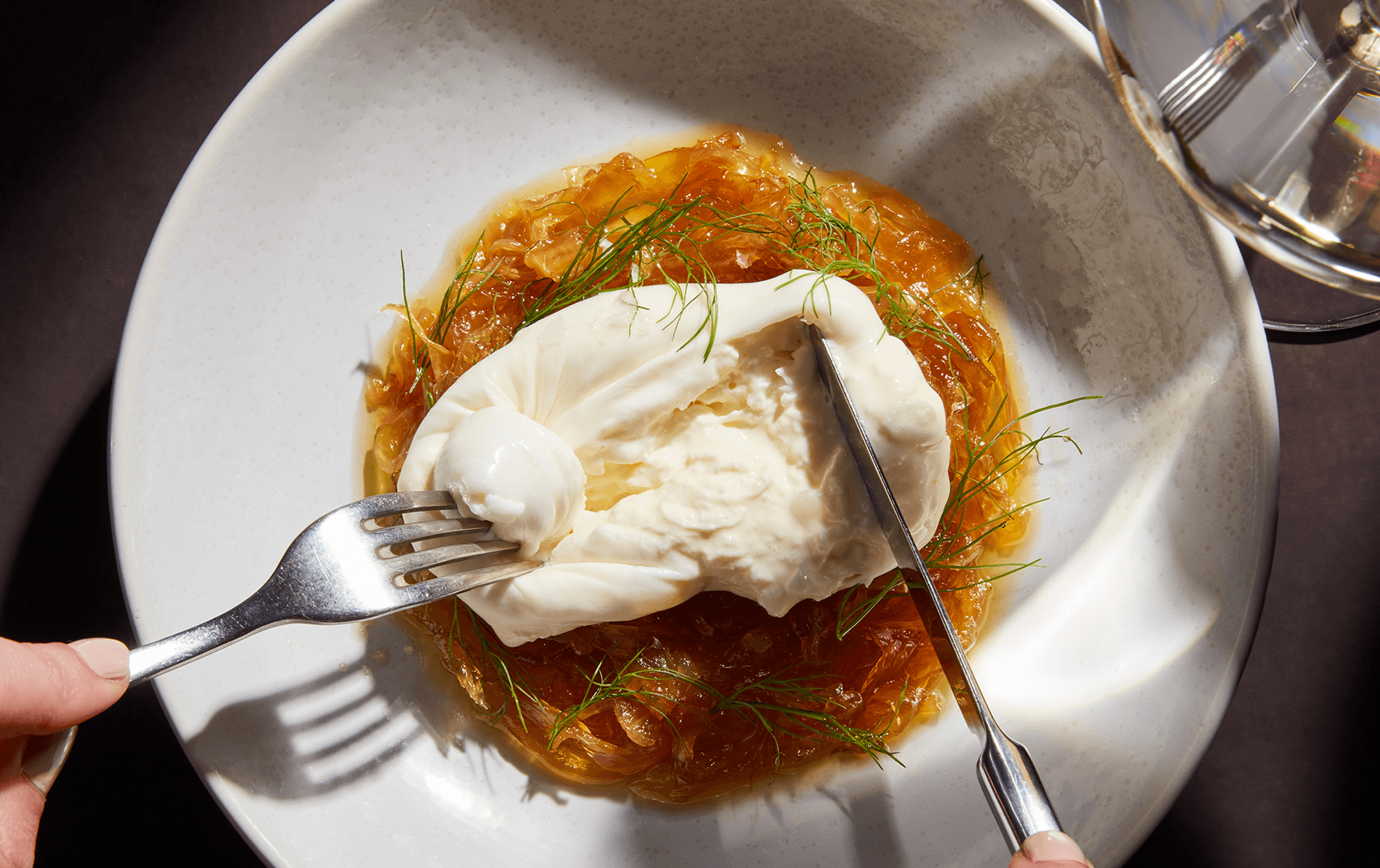 A burrata being cut into by a fork at Nomad, one of Melbourne CBDs best restaurants.