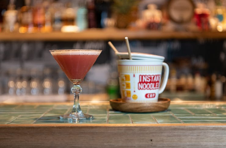 a cocktail and a cup of noodles