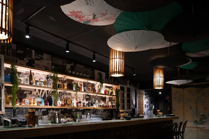 the dark interior of a speakeasy with hanging umbrellas