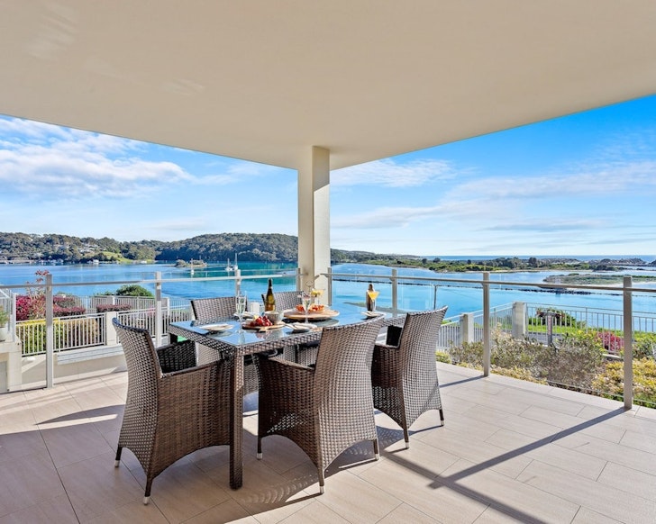 A dining table on the deck at the Luxury Apartment in Narooma one of the best accommodation options in the area