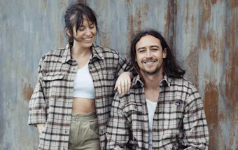 Two people in flannel shirts smiling.