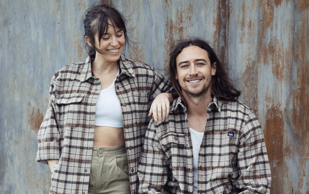 Two people in flannel shirts smiling.