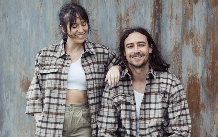 Two people in flannel shirts smiling.