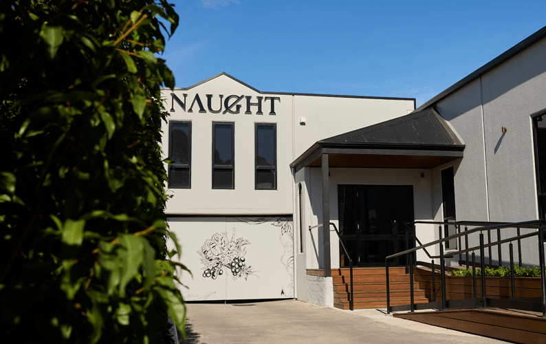 A white building with 'Naught' written at the top of it. Blue skies in the background.
