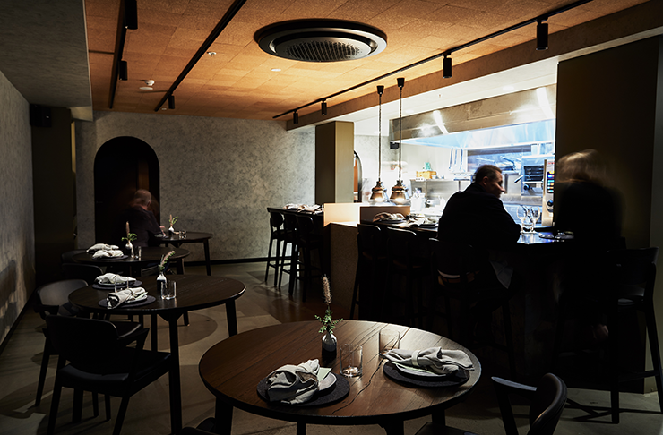 A warmly lit restaurant with tracklights, known as Navi, and considered on of the best in Melbourne.