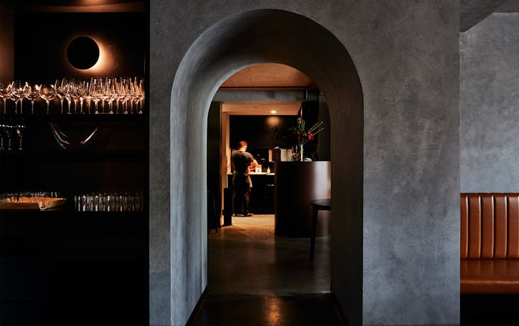 A sleek concrete and wood interior of a cocktail bar Melbourne.