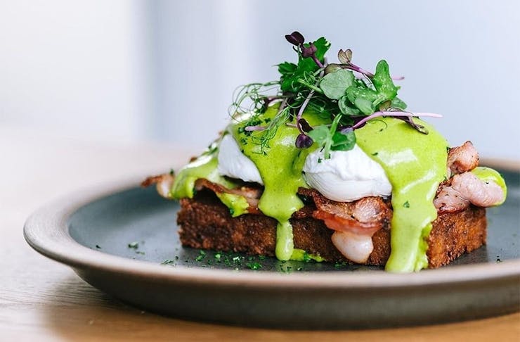A stacked eggs benny on toast with avocado dressing from Neo Cafe in Wellington, one of the best places for breakfast in town.