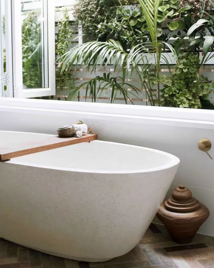 The white bathtub next to the window at Nest At Blue Bay Airbnb, some of the best Central Coast accommodation