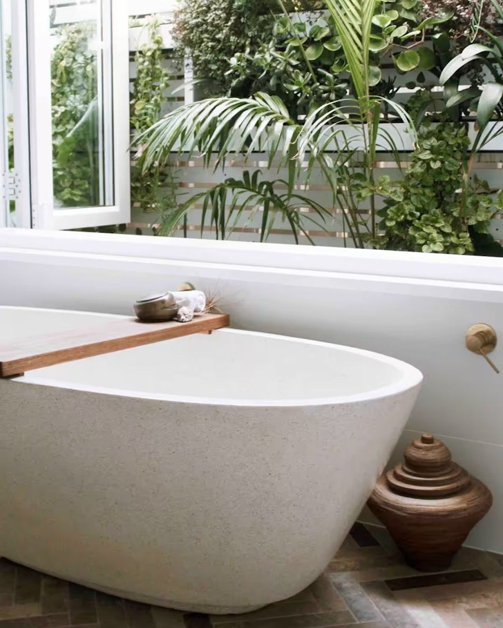 The white bathtub next to the window at Nest At Blue Bay Airbnb, some of the best Central Coast accommodation