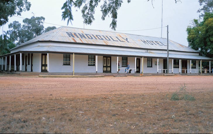 The exterior of Nindigully Pub, with a dirt yard and corrugated iron roof.
