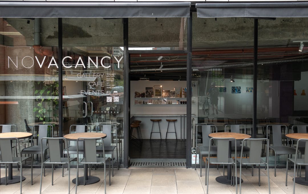 The exterior of a cafe with chairs out front. 