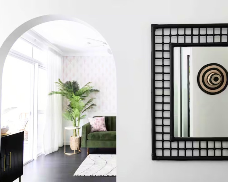 A view through an archway to the living space and balcony at Noir-Luxe one of the best Port Douglas Airbnbs