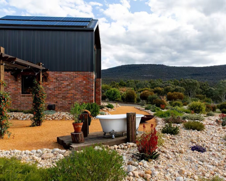 A view of the white bath tub outside Nook on the Hill tiny home in Victoria