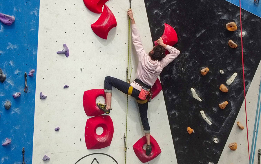 A person reaching on an auto belay at one of the best rock climbing melbourne venues.
