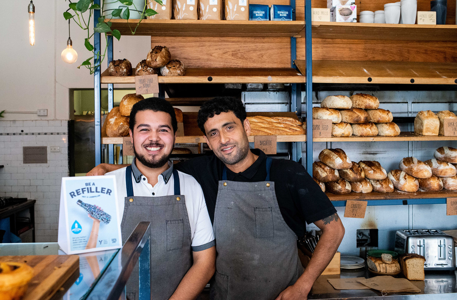 Two men standing in bakery.
